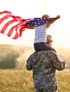 military service member support: soldier holding his child and displaying the American flag